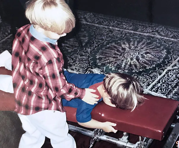 A young boy adjusting a sibling on a chiropractic table, a family photo from the Pyne family
