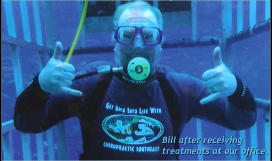 A patient scuba diving in a shark-cage wearing a Get Back Into Life With Chiropractic Southeast shirt